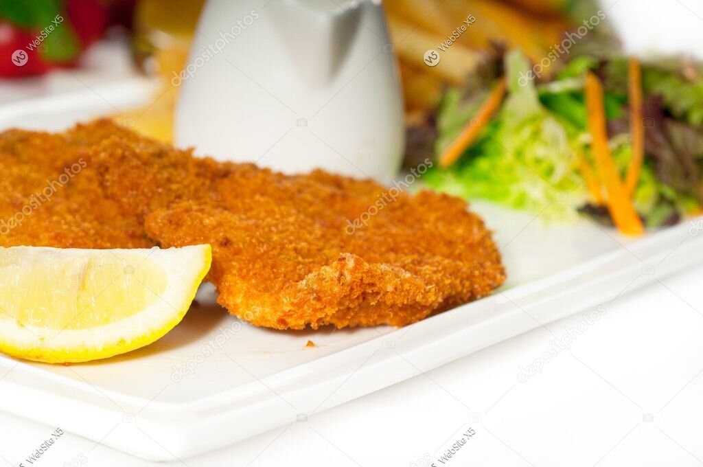 Klassisches Schnitzel mit Pommes und Zitrone